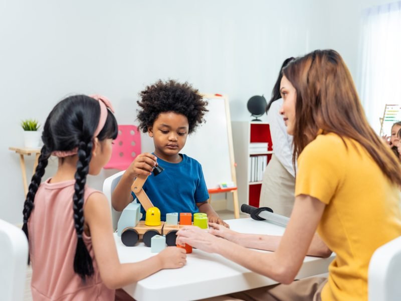 Asian beautiful young woman teacher teaching a lesson to kid at school. Attractive women instructor master explain and educate children student with fun activity in classroom at preschool kindergarten