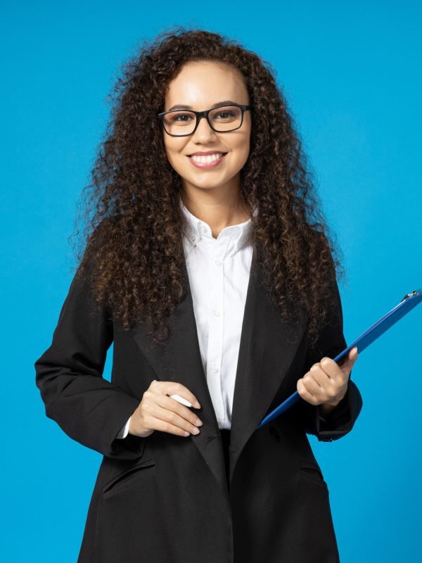 Attractive young girl in glasses and a black suit on a blue background